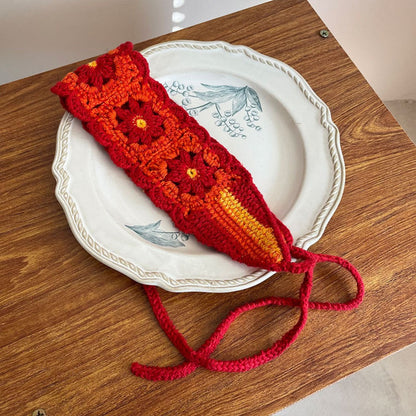 Hand holding crochet flower hairband highlighting flower details
