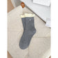 Model seated wearing Rufia ribbed ruffle accent crew socks and loafers