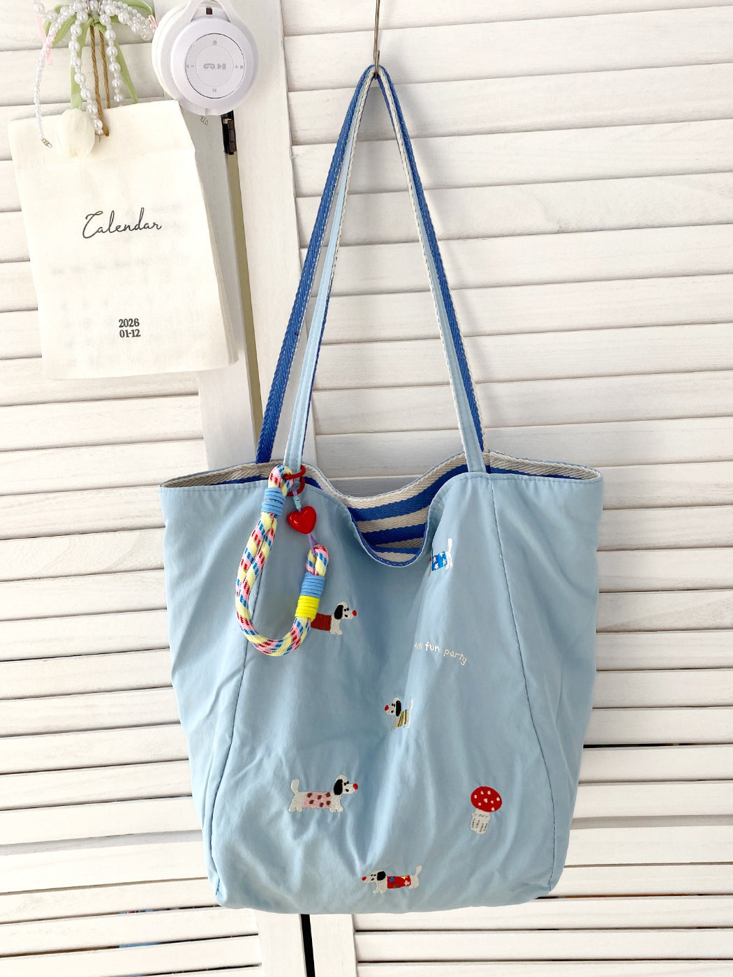 Model carrying Cosbai puppy print tote bag over shoulder outdoors