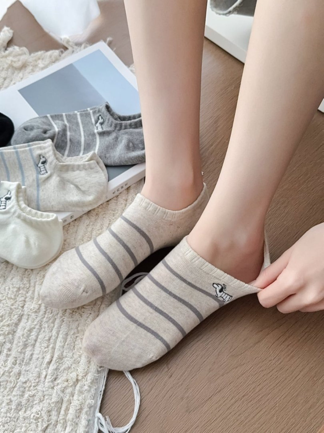 Pair of Rufia Dog Stripe No Show Socks with black dog stripe pattern on white fabric displayed side by side
