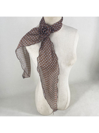Scarf tied around neck showing detailed rose and polka dot design