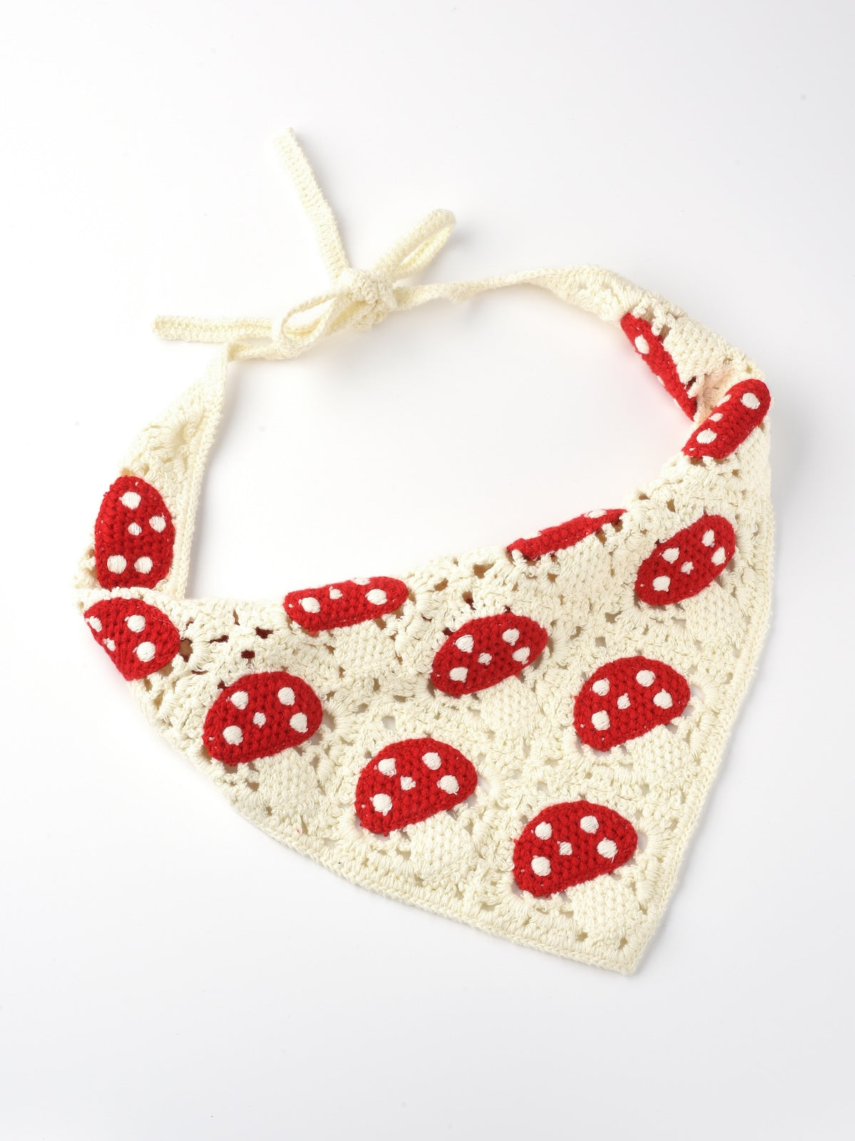 Hand holding crochet hairband with sunflower and mushroom decorations