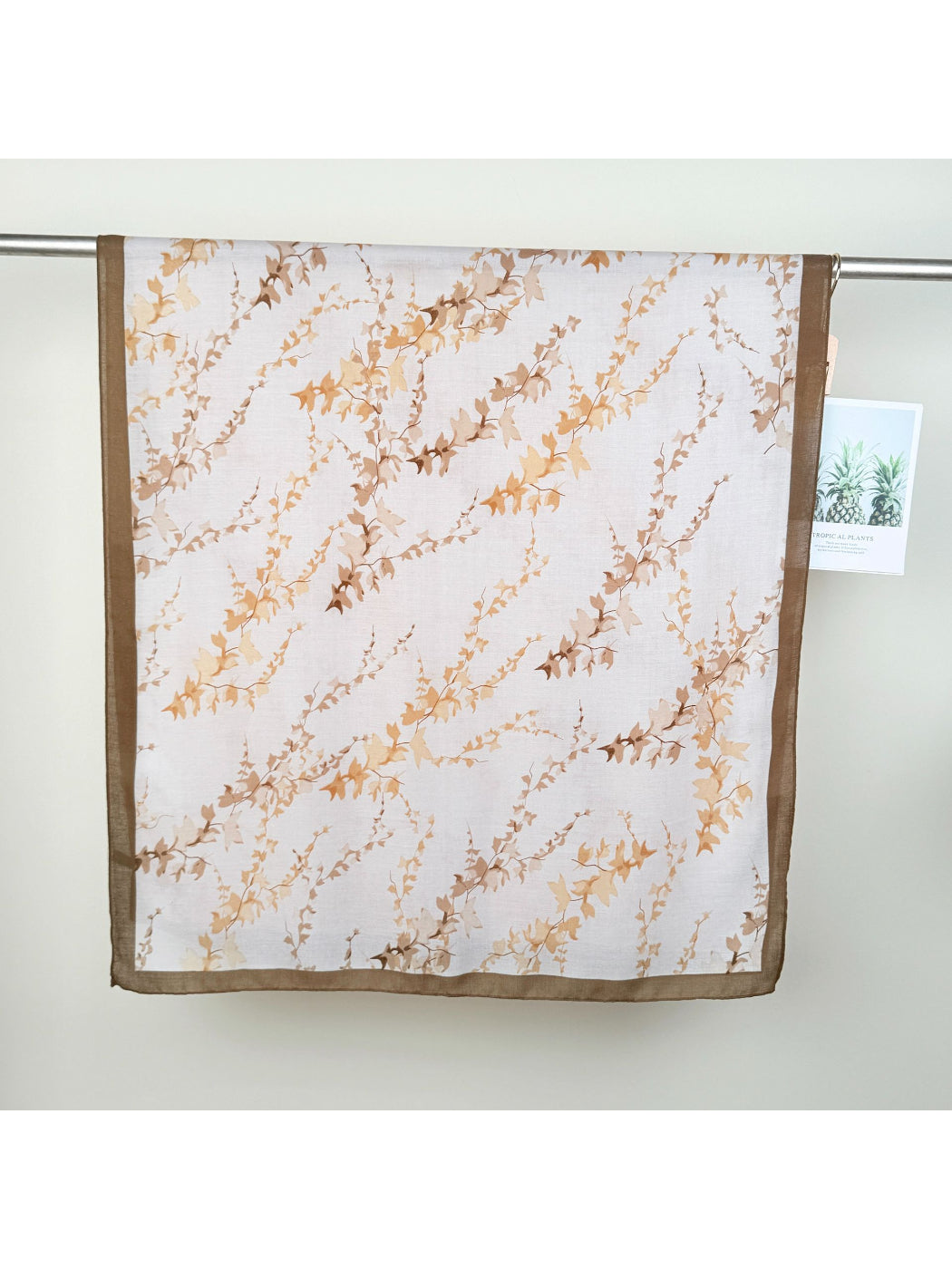 Scarvii wrap scarf draped over shoulders showcasing lightweight fabric and leaf pattern
