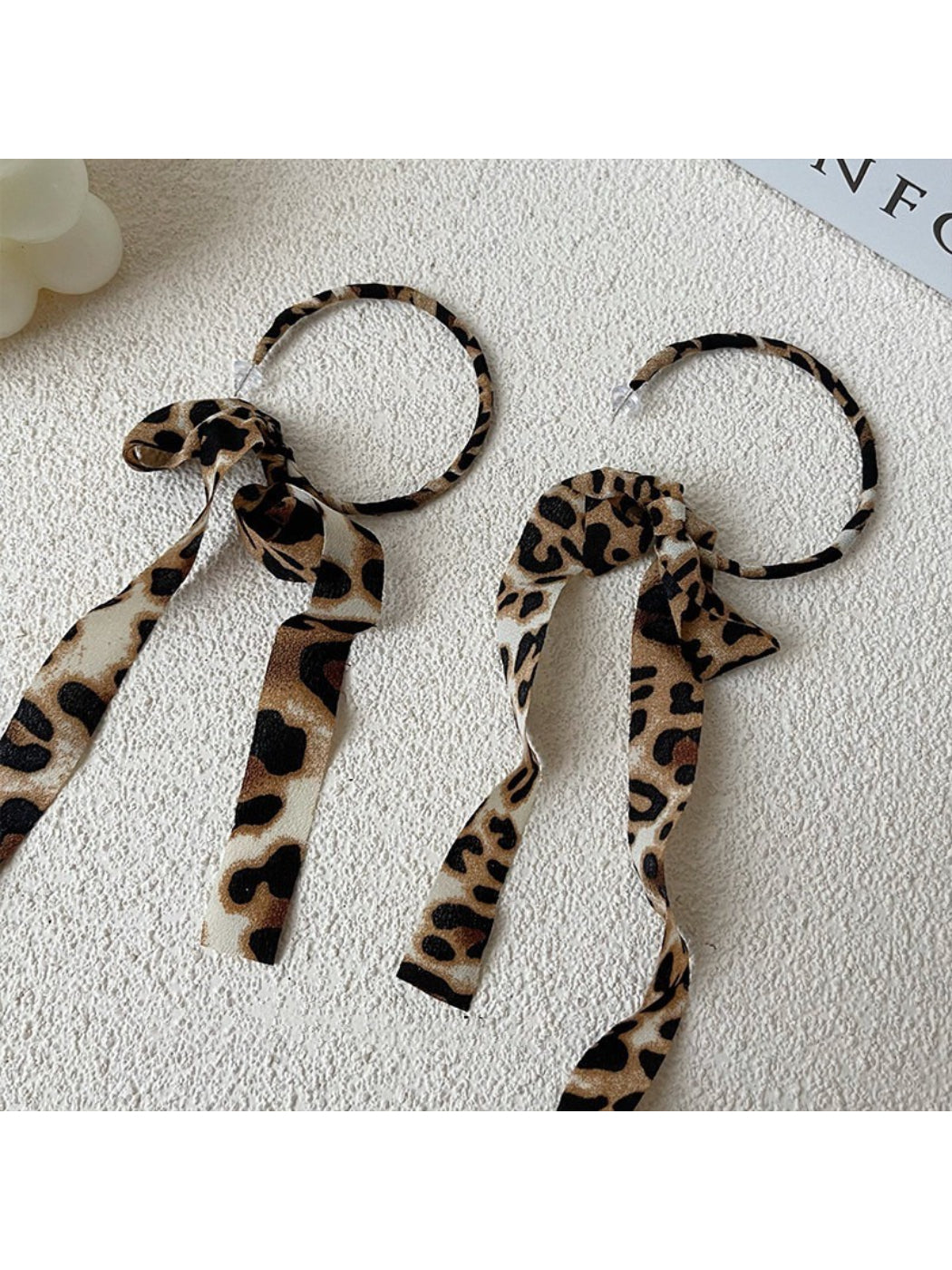 Close-up of Leopard Ribbon Hoop Earrings with gold-tone metal and leopard print ribbon detail