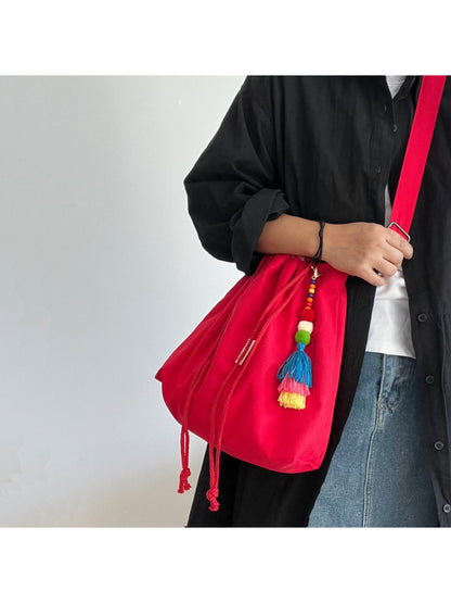 Close-up of gingham trim and tassel on Cosbai bucket bag