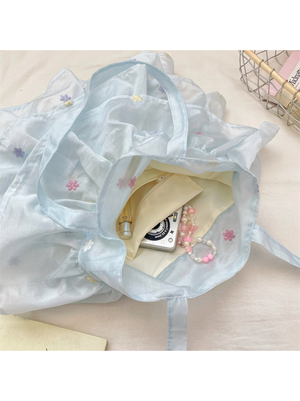 Cosbai pastel mesh ruffle tote bag with beige handles hanging on hook