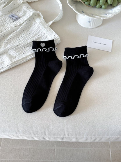 Model wearing Rufia Sweet Heart Edge Ribbed Socks with scalloped heart edges visible above shoes