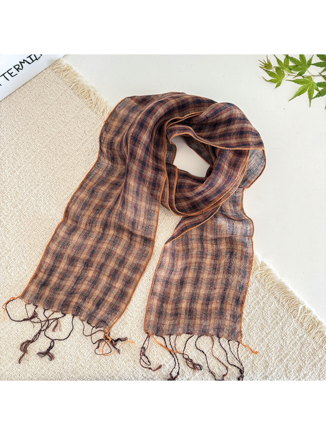 Soft check pattern long skinny scarf wrapped loosely around a mannequin neck