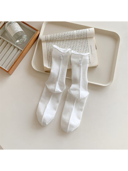 Model wearing Rufia ribbed crew socks with subtle bead detail, styled with casual shoes