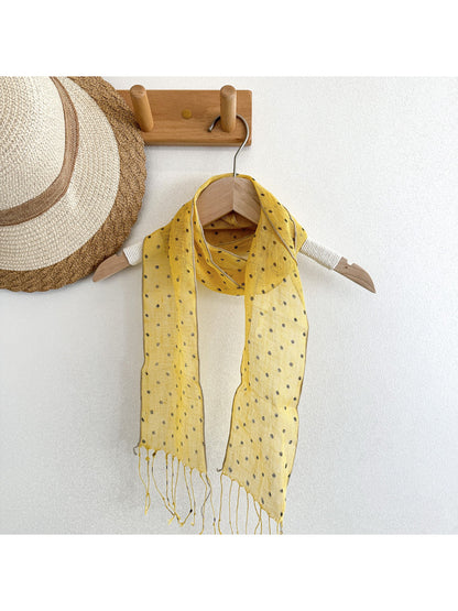 Scarvii polka dot scarf draped over a white blouse on a mannequin
