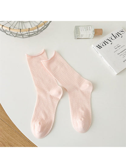 Beige Rufia crew socks arranged to show texture and rolled edge design