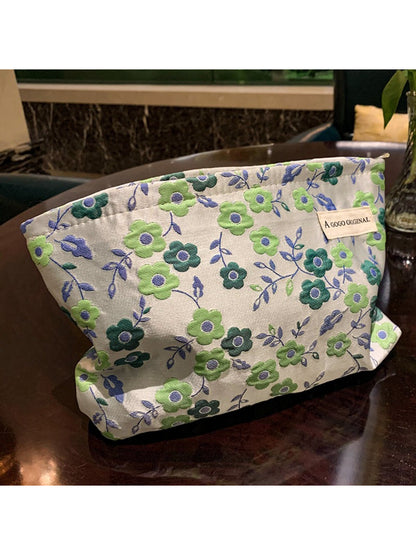 Cosbai floral makeup pouch displayed with makeup brushes and cosmetics