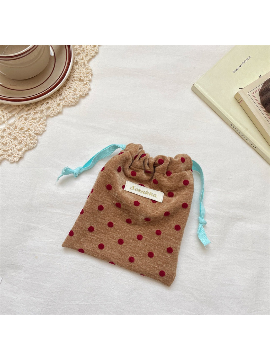 Side view of Cosbai velvet polka dot pouch with drawstring pulled tight