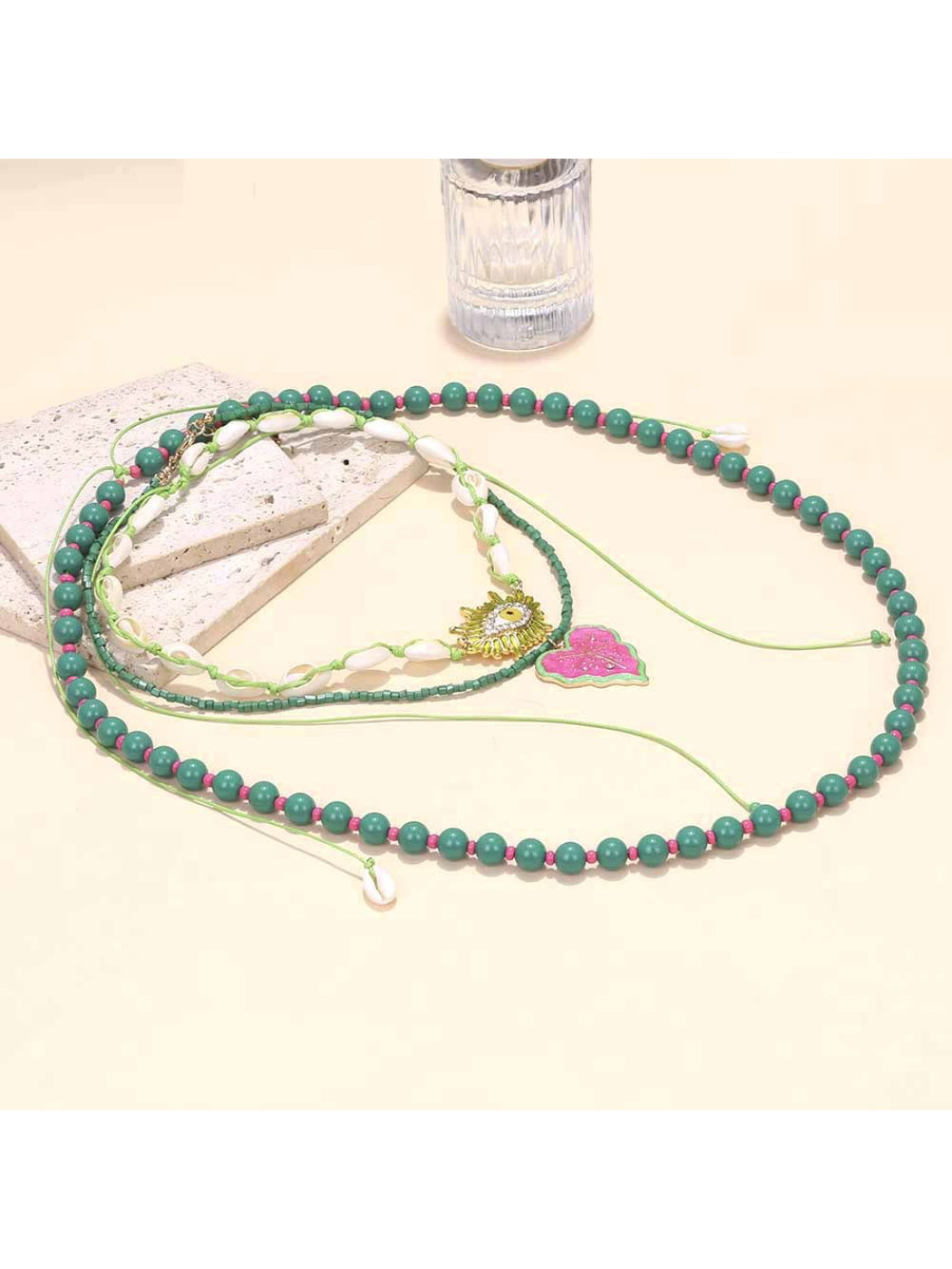 Neckit layered beaded necklace with leaf pendant arranged on a wooden surface