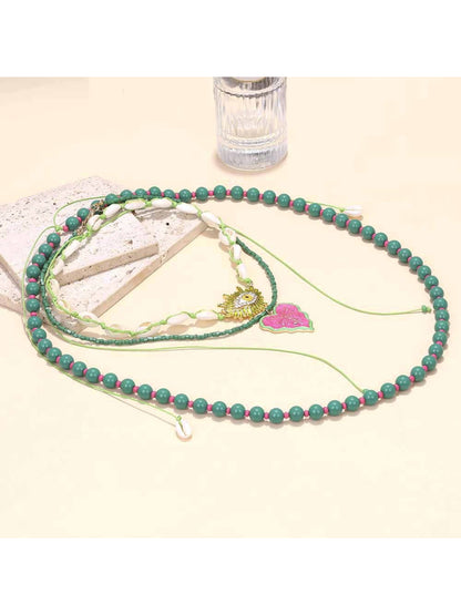 Neckit layered beaded necklace with leaf pendant arranged on a wooden surface