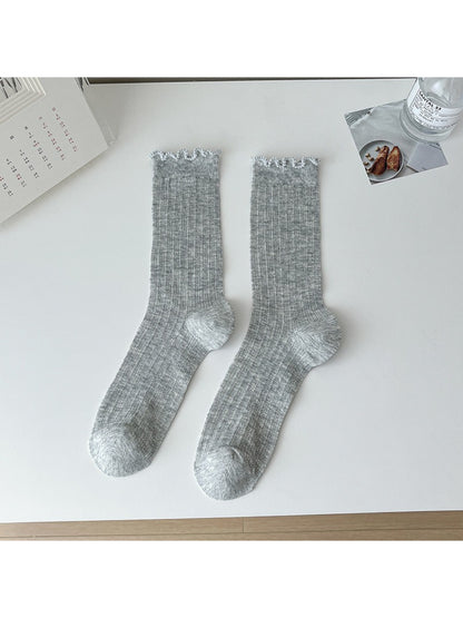 Rufia lace white mid-calf socks folded neatly on a wooden surface