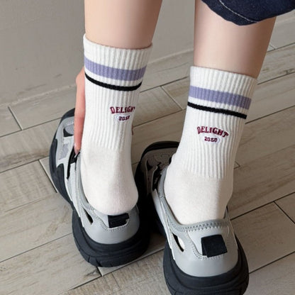 Close-up of Rufia Retro Stripe Letter Crew Socks showing detailed knit stripes and letter pattern