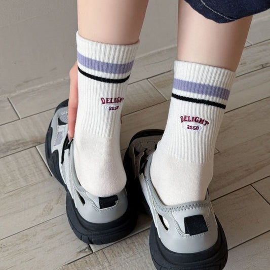 Close-up of Rufia Retro Stripe Letter Crew Socks showing detailed knit stripes and letter pattern