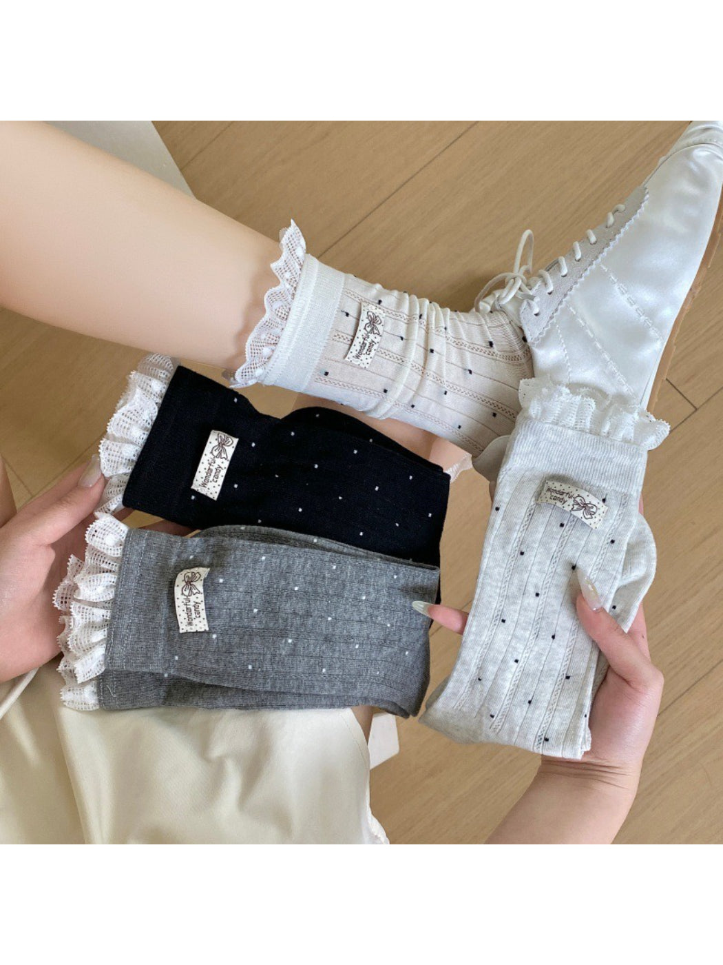 Pair of soft ribbed socks with black polka dots on a beige background