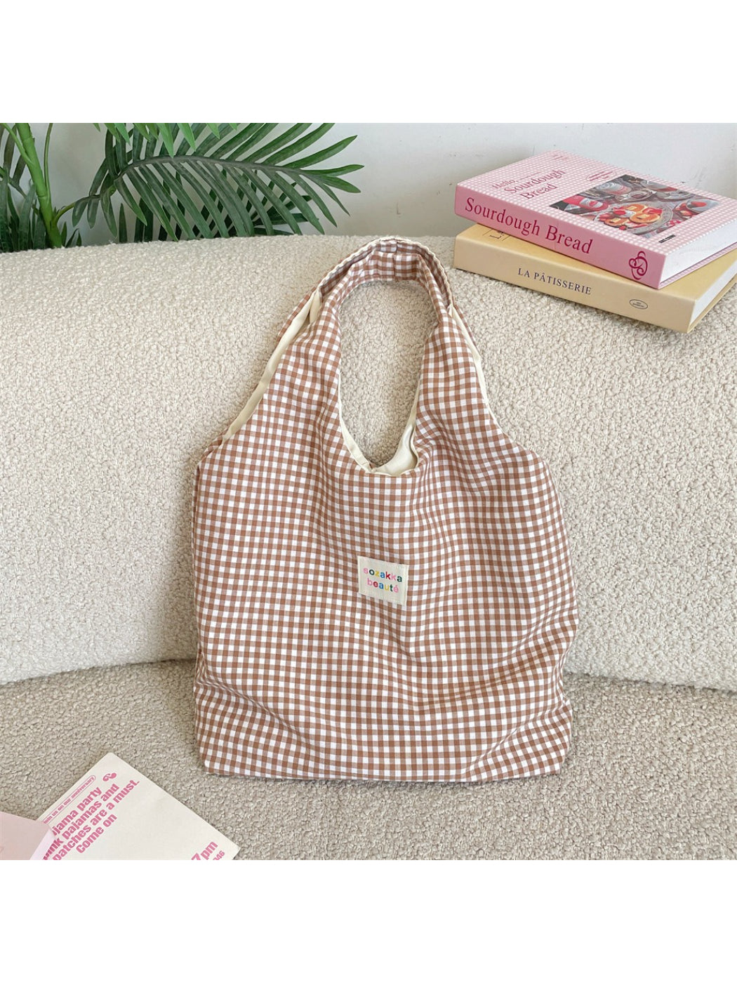 Model carrying Cosbai check pattern slouchy tote bag over shoulder outdoors