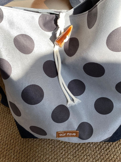 Cosbai polka dot crossbody bag hanging on hook with drawstring pulled tight