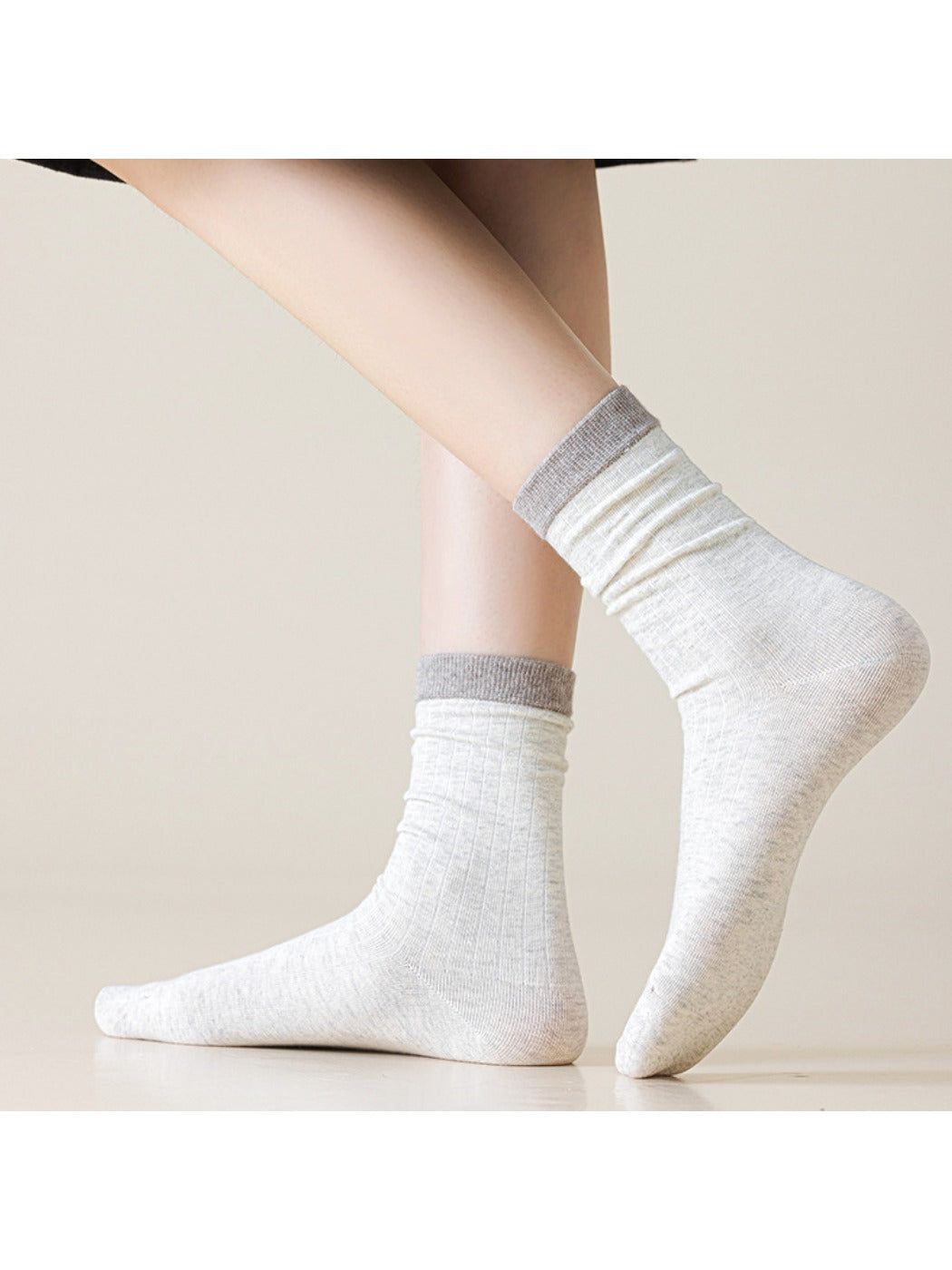 Close-up of beige Rufia ribbed mid-calf sock fabric texture and stitching