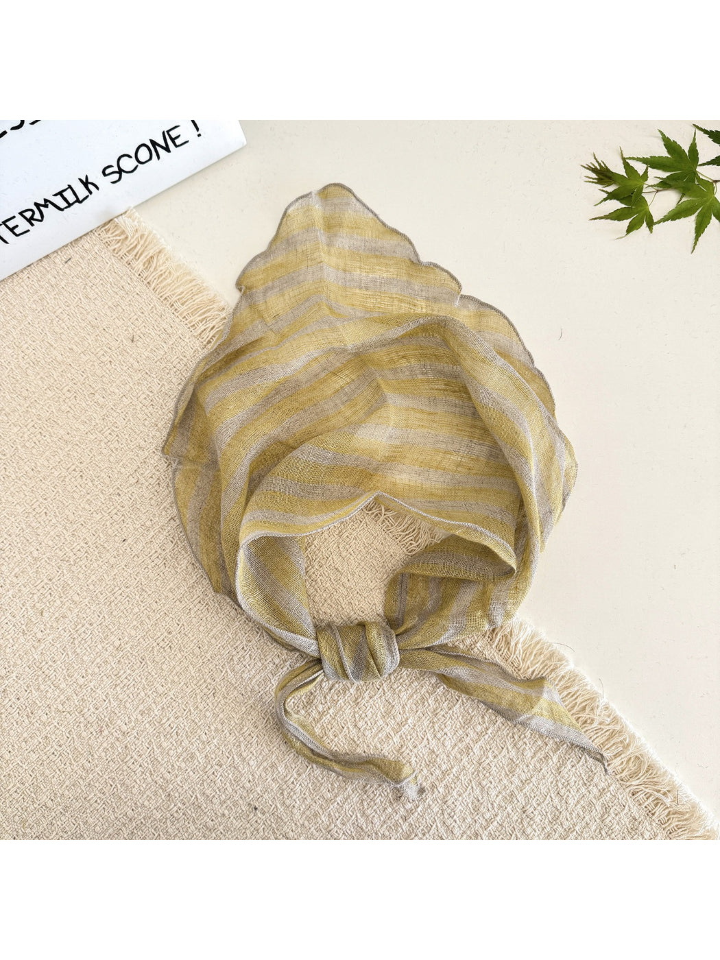 Soft textured stripe head scarf draped over a wooden surface