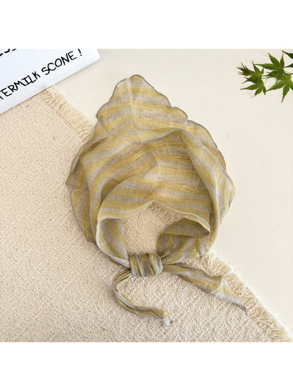 Soft textured stripe head scarf draped over a wooden surface