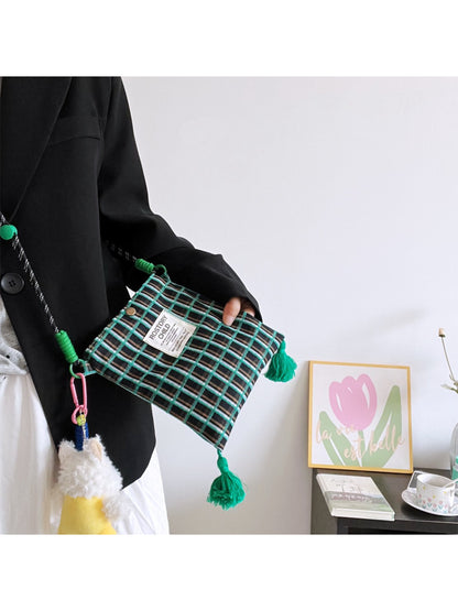 Cosbai plaid phone bag with attached dog charm on a white background