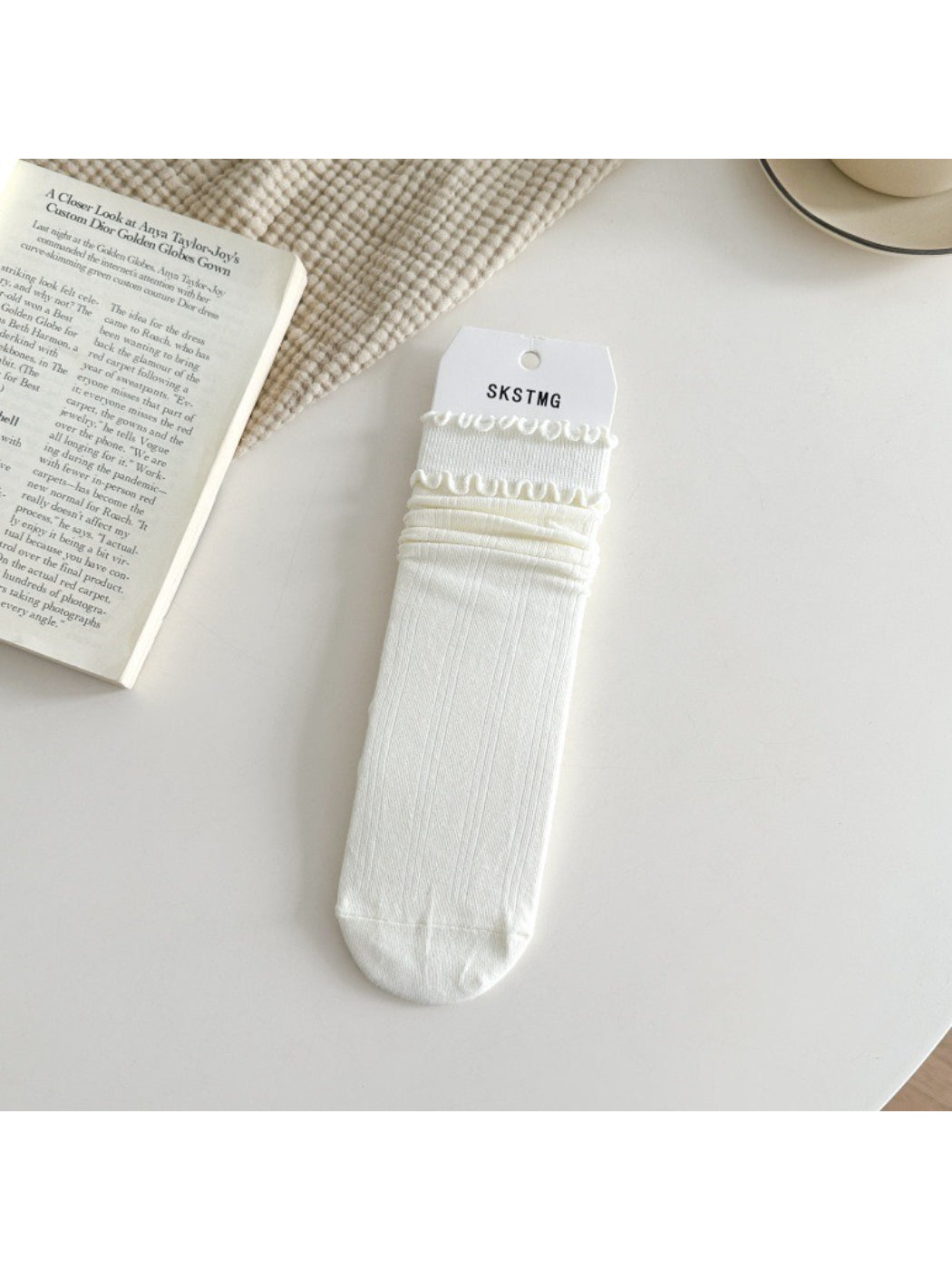 Rufia ruffle mid-calf socks in beige color folded neatly