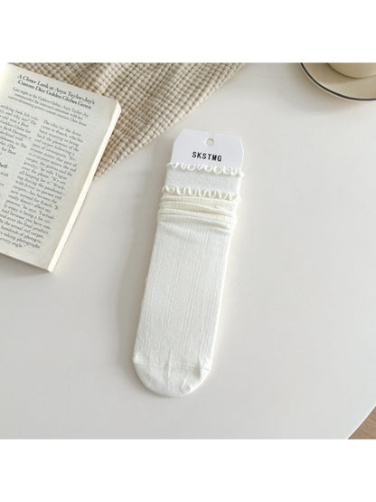 Rufia ruffle mid-calf socks in beige color folded neatly