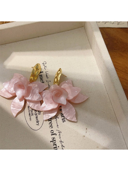 Artistic floral drop earrings shown with a focus on the metalwork and flower details