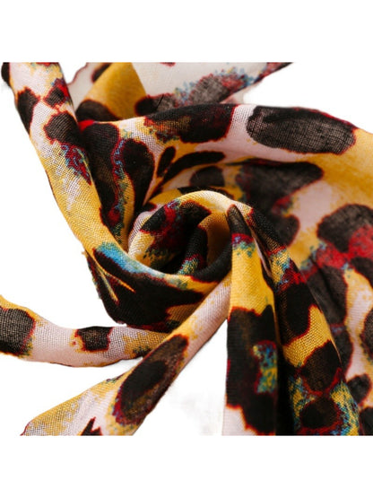 Scarvii scarf draped over shoulders showcasing full leopard print design and tassel details