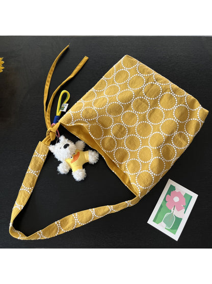 Side view of Cosbai shoulder tote showing textured circle design and dog charm detail