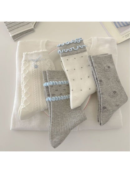 Pair of Rufia Dreamy Blue Trim Mixed Crew Socks laid flat showing blue trim and mixed patterns