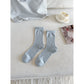 Pair of Rufia Everyday Turn Cuff Knit Socks folded neatly on wooden surface