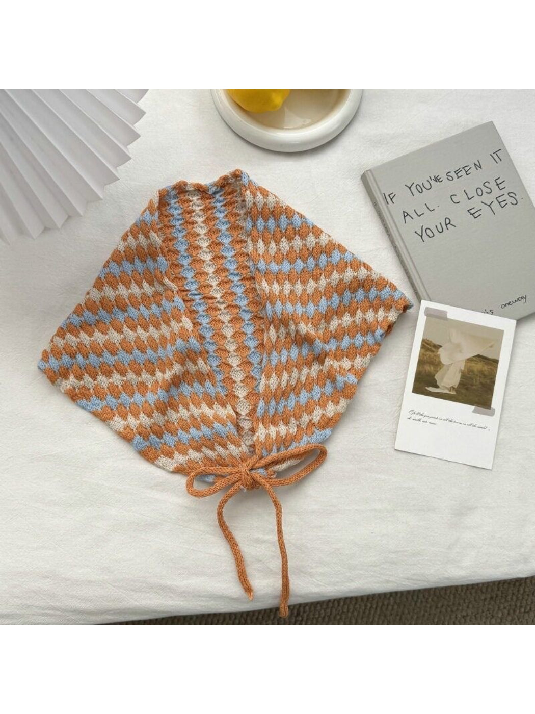 Flat lay of cream open knit diamond triangle scarf folded neatly