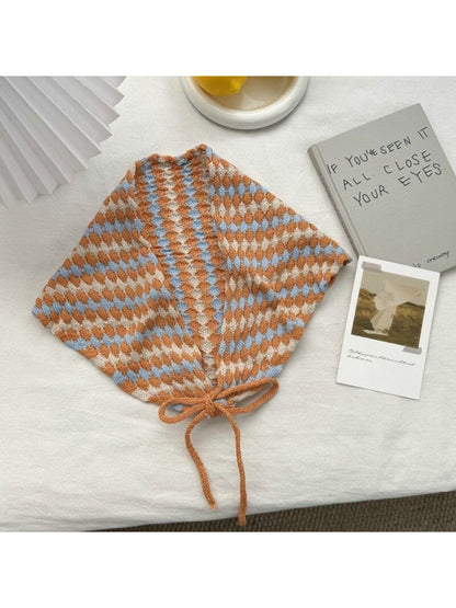 Flat lay of cream open knit diamond triangle scarf folded neatly