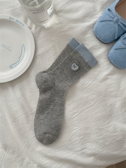 Rufia lightweight floral knit crew socks displayed on wooden surface with soft lighting
