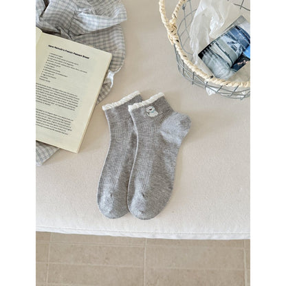 Rufia ankle socks folded with visible pink ribbon accent on white fabric