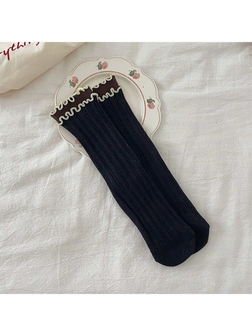 Pair of Rufia ruffle color block crew socks folded to show ruffle and color block design