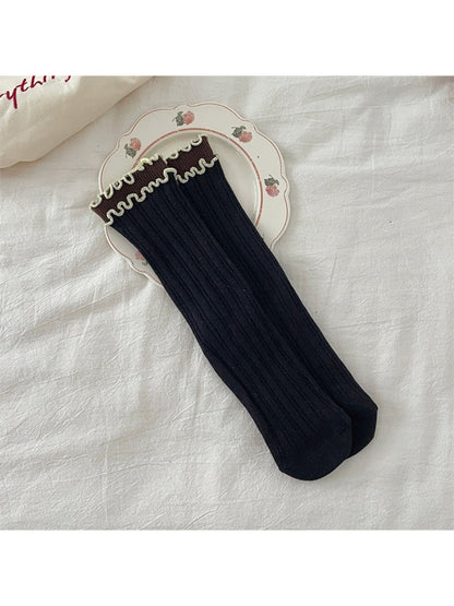 Pair of Rufia ruffle color block crew socks folded to show ruffle and color block design