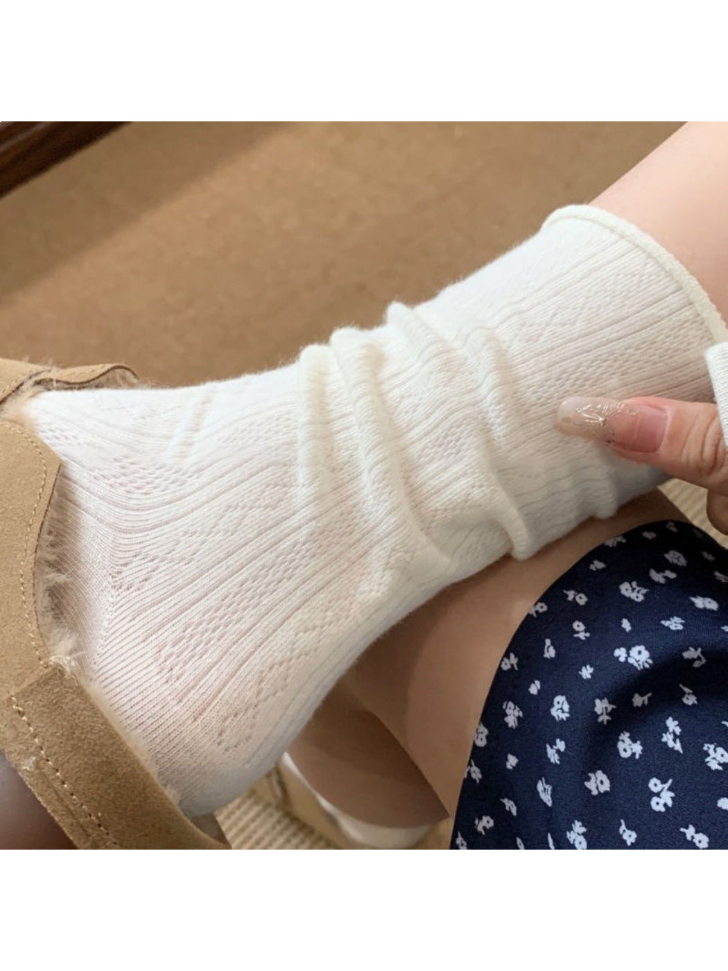 Pair of white mid-calf socks laid flat on a white background