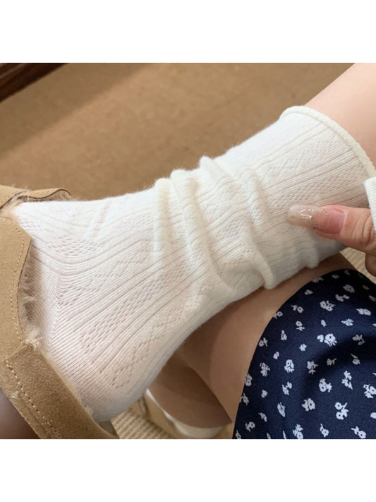 Pair of white mid-calf socks laid flat on a white background