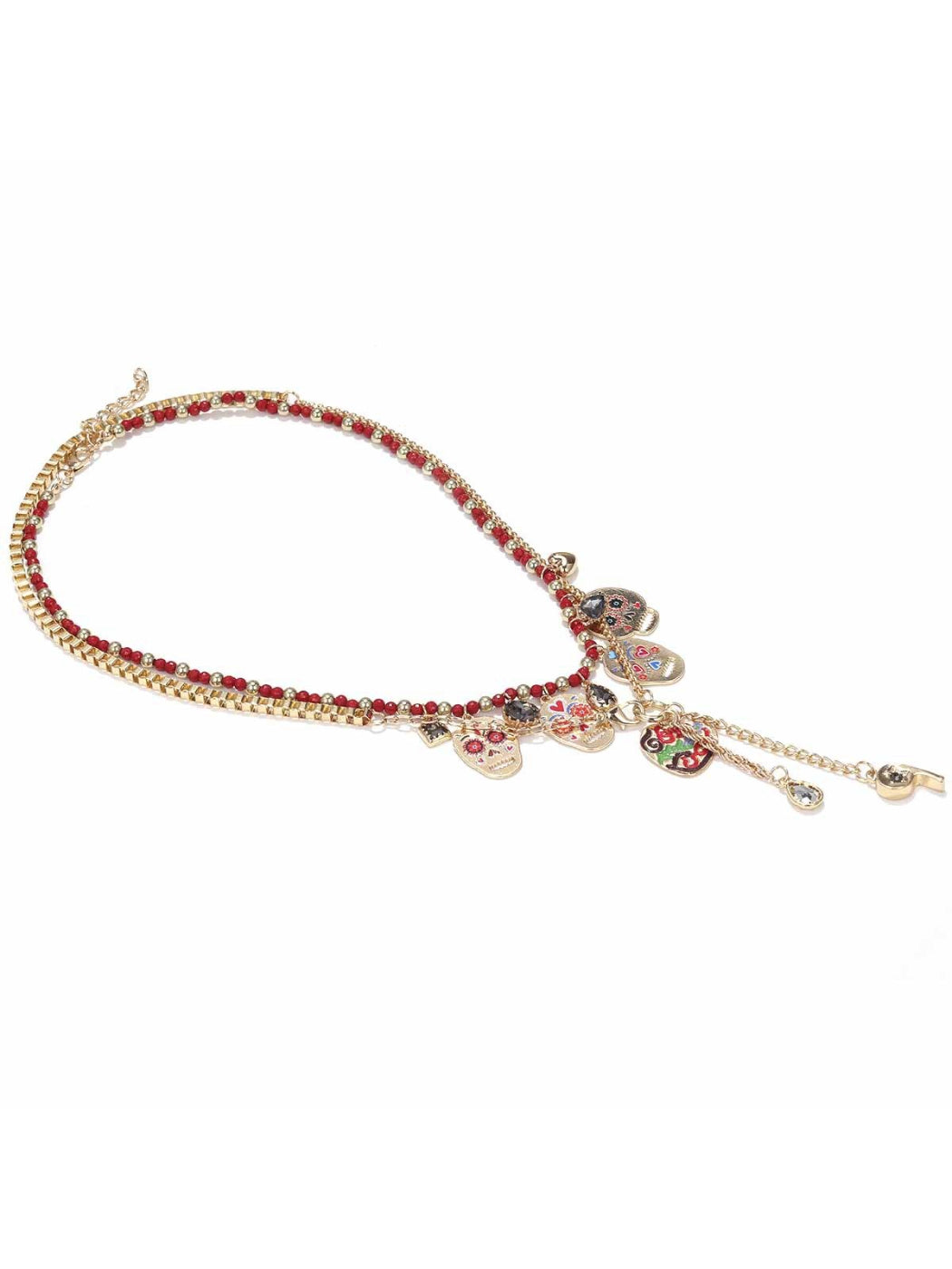Close-up of Neckit skull charm layered necklace with red beads displayed on a black surface