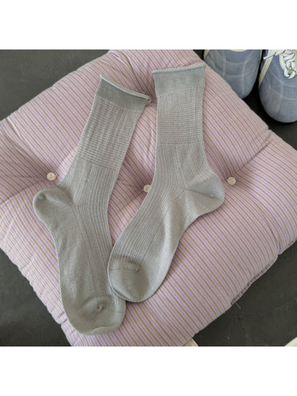 Stack of Rufia soft knit everyday crew socks in various neutral colors