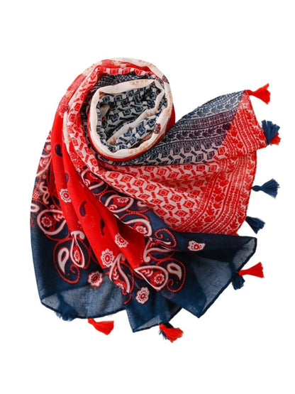 Model wearing red boho border wrap scarf styled around the neck outdoors
