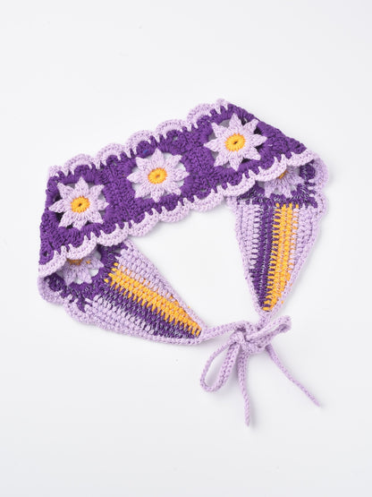 Close-up of multicolored crochet flowers on hairband with green leaves
