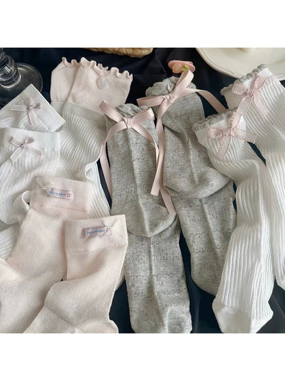 Close-up of Rufia Romantic Bow Texture crew socks in soft pink with bow detail
