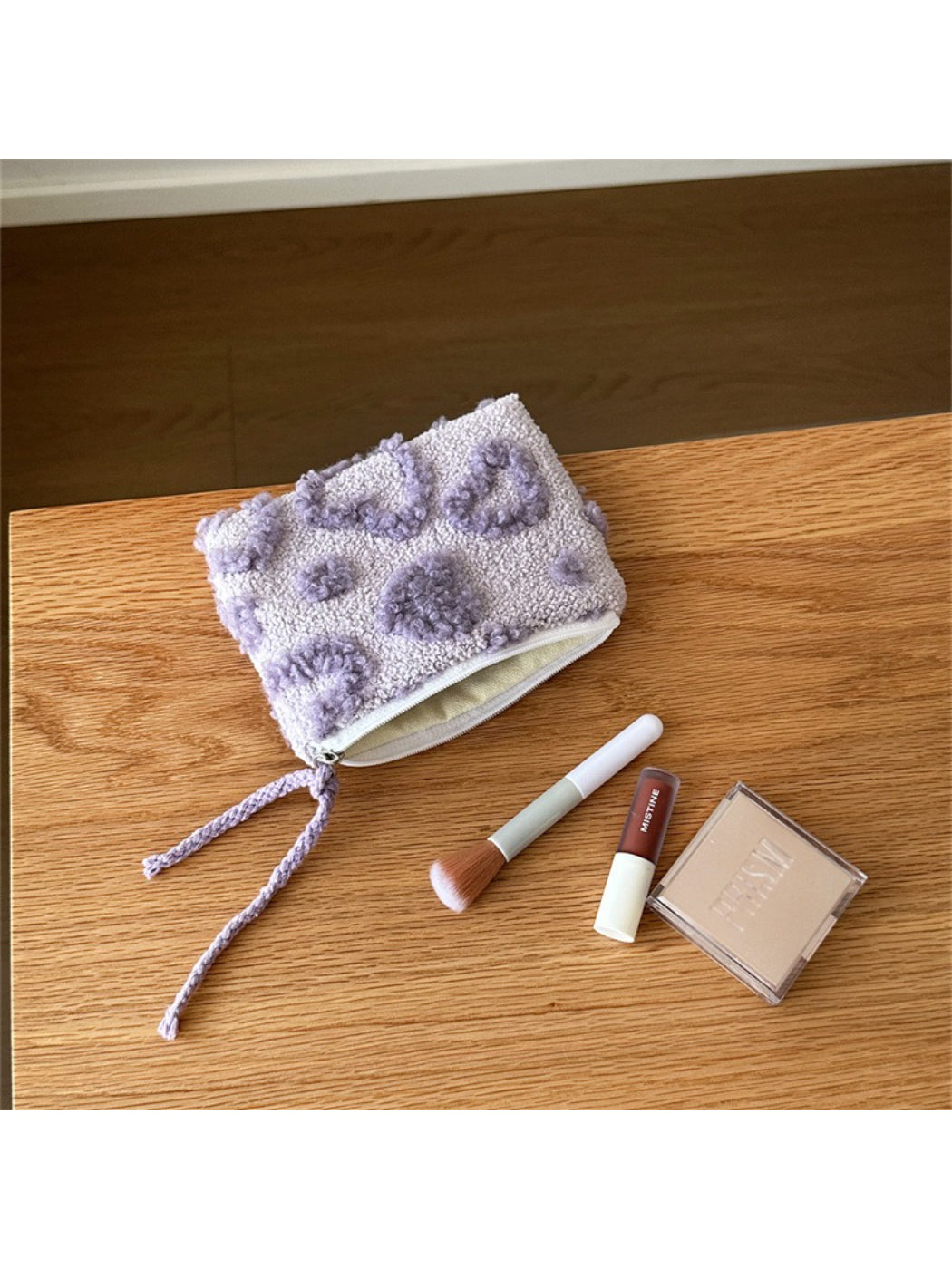 Cosbai heart-shaped plush pouch next to small gift items for scale